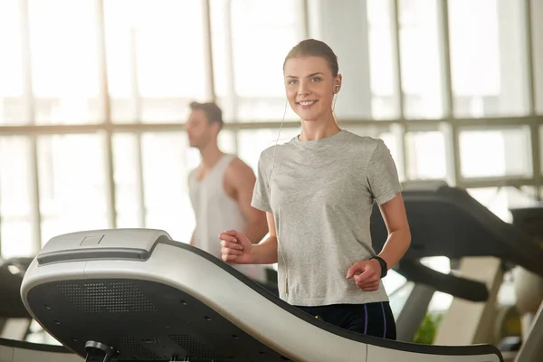 Ajuste mujer joven corriendo en la cinta de correr. — Foto de Stock