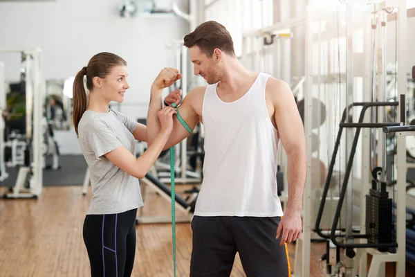 Young sporty man and woman at gym. — Stock Photo, Image