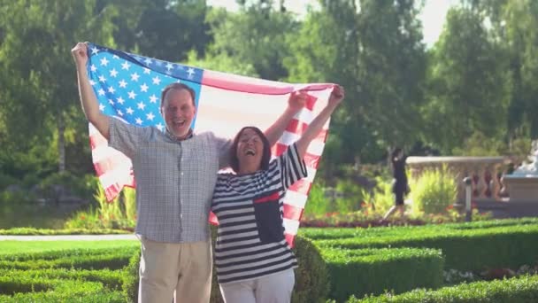 Feliz pareja madura sosteniendo bandera americana. — Vídeos de Stock