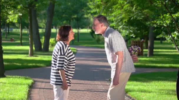 Romantico uomo anziano che dà bouquet a sua moglie al parco. — Video Stock