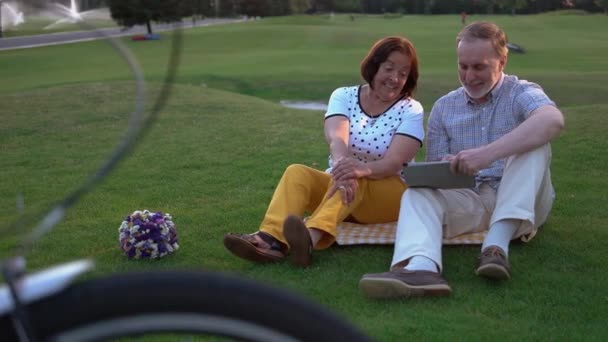 Happy caucasian seniors using pc tablet outdoors. — Stock Video