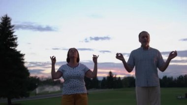 Olgun çift dışarıda meditasyon yapıyor..