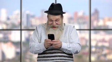 Komik kıdemli adam cep telefonu kullanıyor..