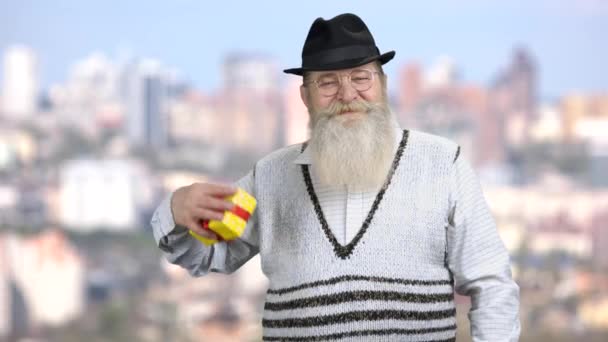 Gelukkige man met baard wijzend naar geschenkdoos. — Stockvideo