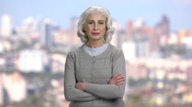 Bulanık şehir arka planında olgun bir kadının portresi.