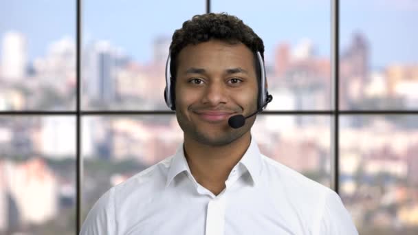 Glimlachende call center operator op windows achtergrond. — Stockvideo