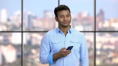 Kendine güvenen genç bir adam telefonla fotoğraf çekiyor..