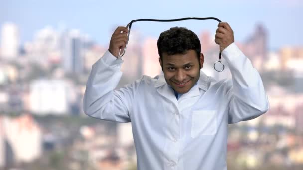 Młody indyjski lekarz zakładający stetoskop. — Wideo stockowe
