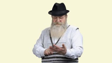 Şeffaf plastik cihaz kullanan sakallı yaşlı adam..