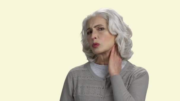 Ώριμη γυναίκα με πόνο στο λαιμό σε λευκό φόντο. — Αρχείο Βίντεο