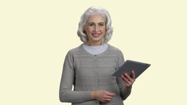 Elég érett nő kezében pc tabletta fehér háttér. — Stock videók