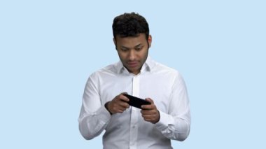 Cep telefonuyla oyun oynayan etkileyici iş adamı.