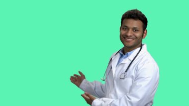 Neşeli erkek doktor elleriyle fotokopi odasını gösteriyor..