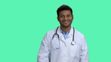 Gülümseyen doktor hapları gösteriyor ve başparmağını kaldırıyor.