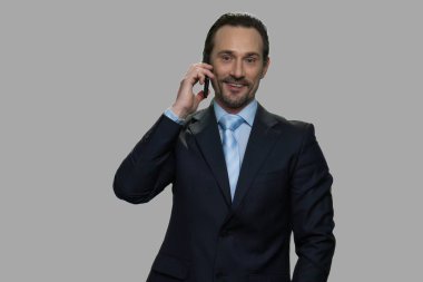 Gülümseyen beyaz iş adamı cep telefonuyla konuşuyor..