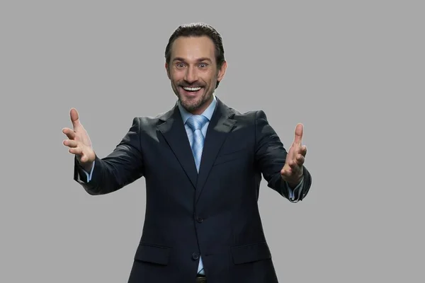 Happy excited businessman on gray background. — Stock Photo, Image