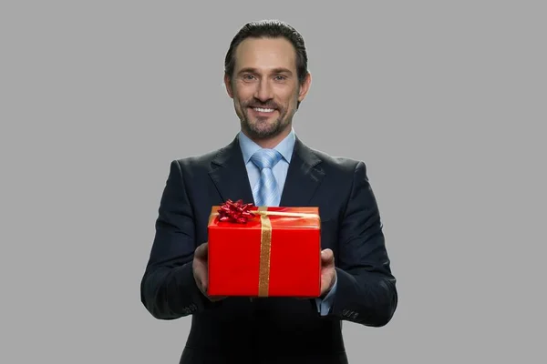 Allegro uomo d'affari che offre scatola regalo. — Foto Stock