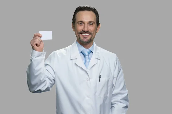 Mosolygó férfi orvos névjegykártyával. — Stock Fotó