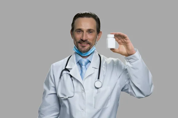 Професійний чоловічий лікар, що показує пляшку таблеток . — стокове фото