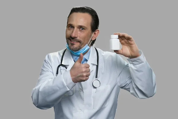 Hombre médico mostrando botella de pastillas y el pulgar hacia arriba. — Foto de Stock