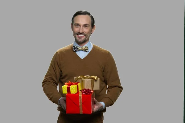 Smiling mature man holding gift boxes. — Stock Photo, Image