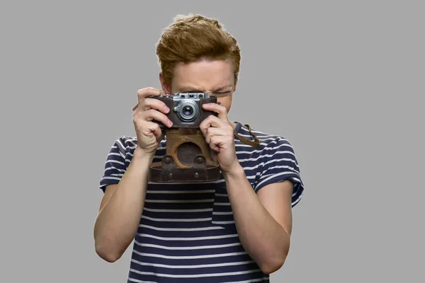 Nastolatek chłopiec za pomocą rocznika aparat. — Zdjęcie stockowe