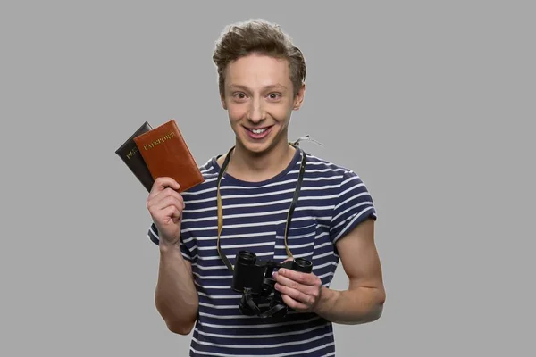 Retrato de jovem menino feliz segurando passaportes e binóculos. — Fotografia de Stock