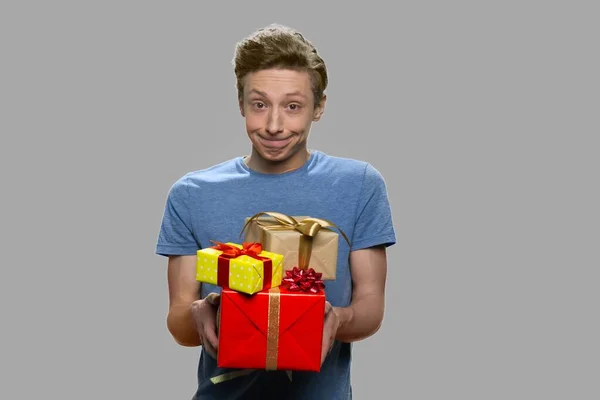 Lustige Teenie-Junge bietet Geschenk-Boxen. — Stockfoto
