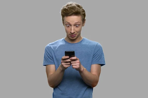 Sorprendido adolescente usando el teléfono móvil. — Foto de Stock