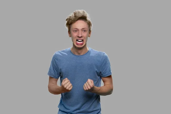 Irritado estressado adolescente menino gritando em fundo cinza. — Fotografia de Stock