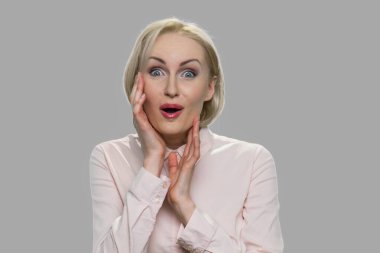 Gri arka planda sersemlemiş bir kadın.