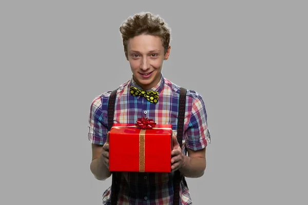 Schüchtern teen boy holding gift box. — Stockfoto