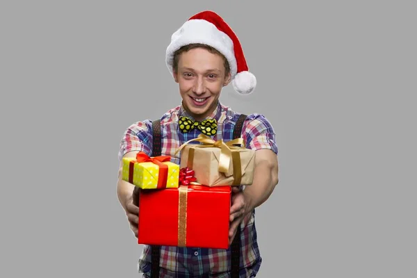 Divertido chico adolescente entregando cajas de regalo de Navidad. —  Fotos de Stock