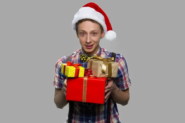 Menino de Natal com caixas de presente no fundo cinza. — Fotografia de Stock