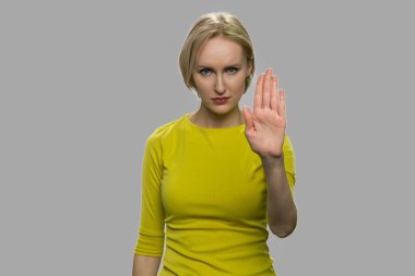 Kendine güvenen genç bir kadın dur işareti yapıyor..