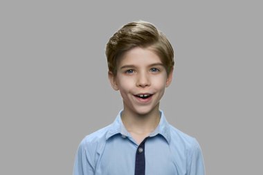 Gri arka planda yakışıklı çocuğu kapat.