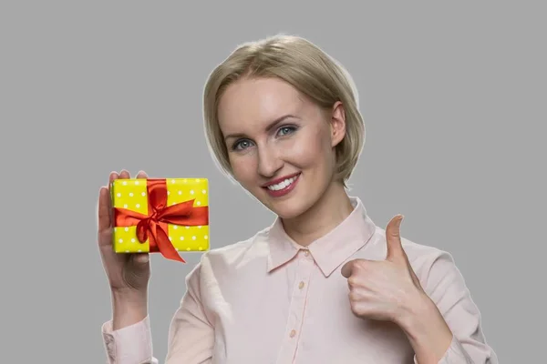 Mujer mostrando caja de regalo y pulgar hacia arriba. — Foto de Stock