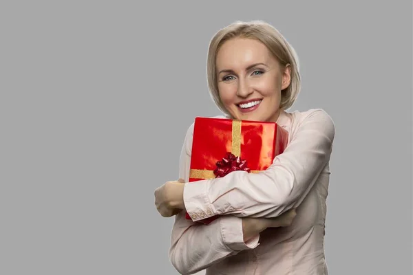Giovane donna eccitata in possesso di scatola regalo rossa. — Foto Stock