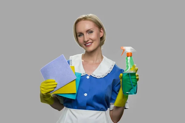 Huishoudster in uniform bedrijf schoonmaakmiddelen. — Stockfoto