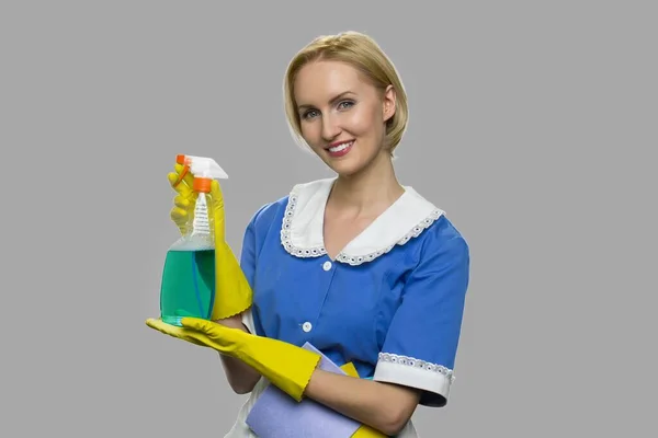Hübsch lächelnde Haushälterin hält Putzspray in der Hand. — Stockfoto