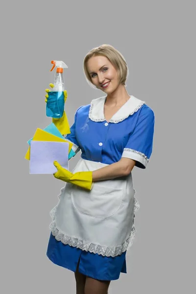 Atractiva criada mujer sosteniendo spray limpiador. —  Fotos de Stock