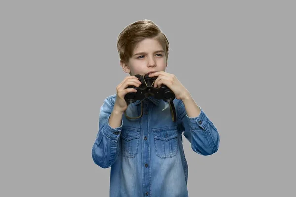 Piccolo ragazzo caucasico usando il binocolo . — Foto Stock