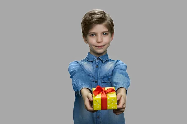 Adorable kid giving gift box to camera. — Stock Photo, Image