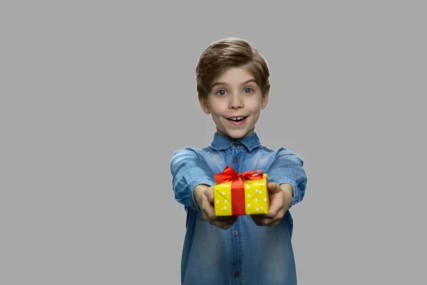 Милий веселий хлопчик дарує подарункову коробку камері . — стокове фото