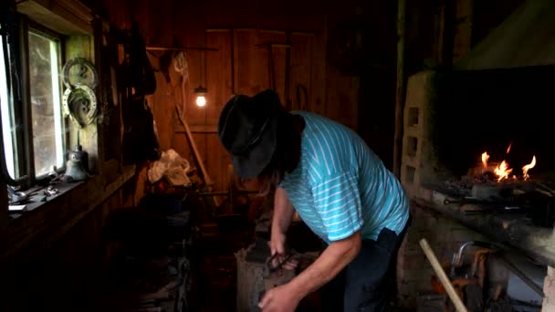 Кузнец, работающий с металлом в кузнице. — стоковое видео