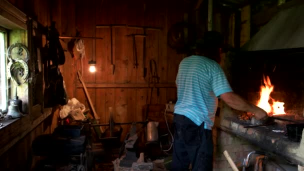 Кузнец, работающий в печи в своей мастерской. — стоковое видео