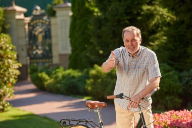Bisikletli yaşlı adam başparmağını kaldırdı..