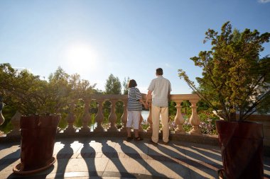 Arka manzara çifti gölete bakıyor ve el ele tutuşuyorlar..