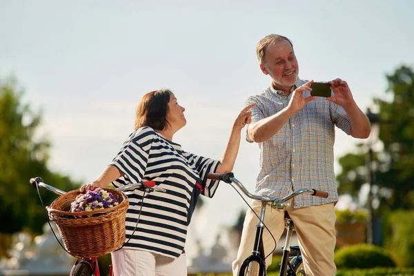 Turistas idosos felizes com bicicletas e câmera de fotos. — Fotografia de Stock