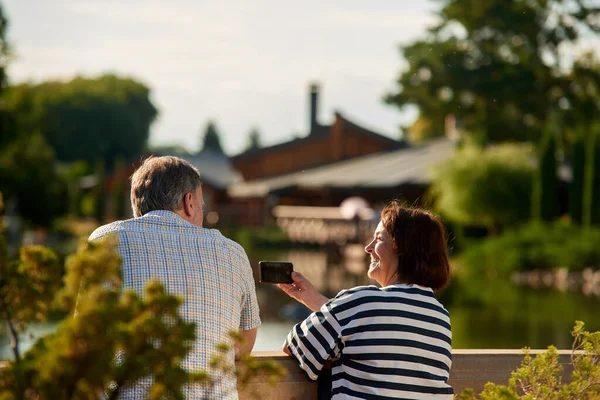 Arkadan bakan adam ve kadın dışarıda oturuyor..